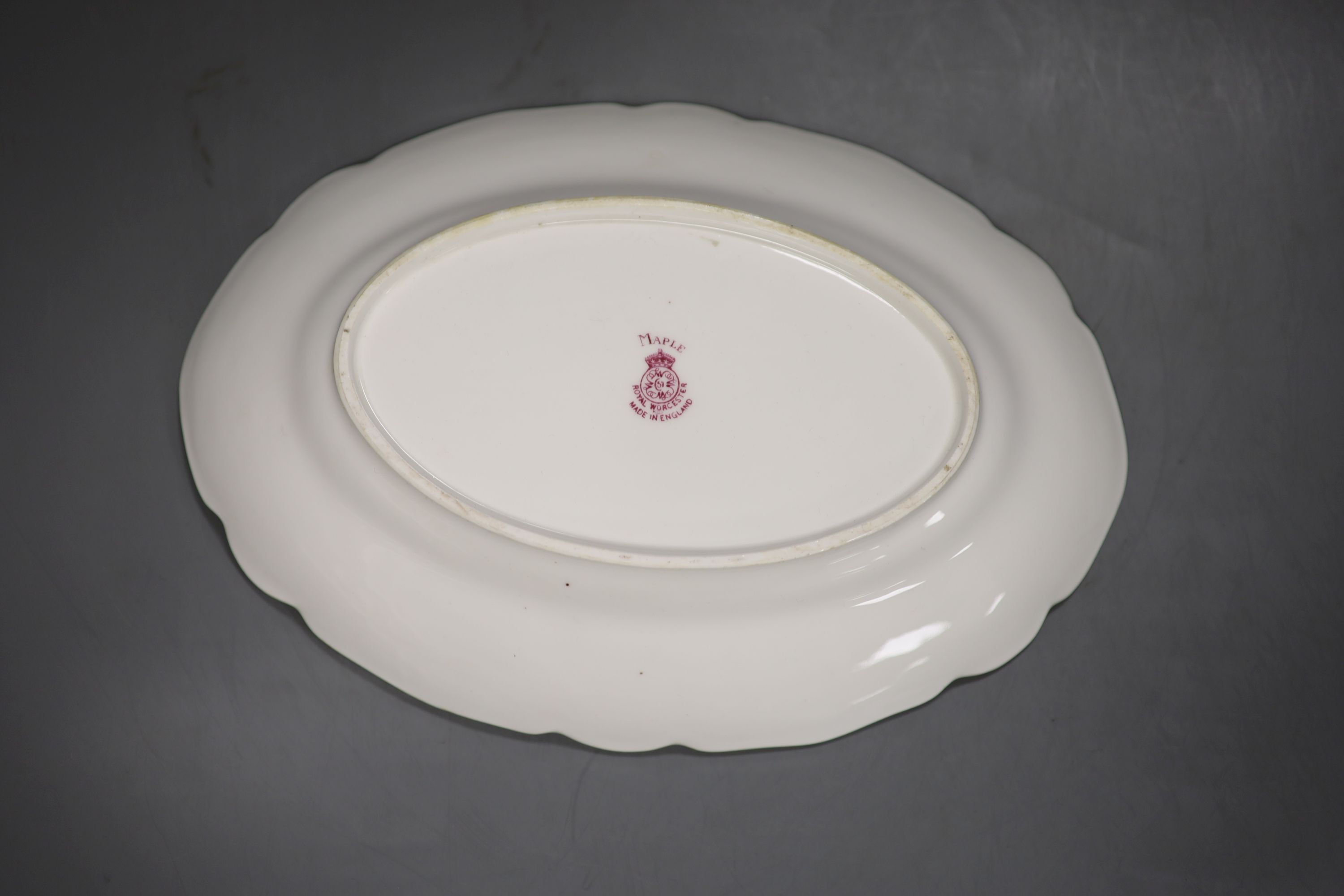 A Royal Worcester oval dish painted with autumnal leaves and berries by Kitty Blake, signed, date mark 1933